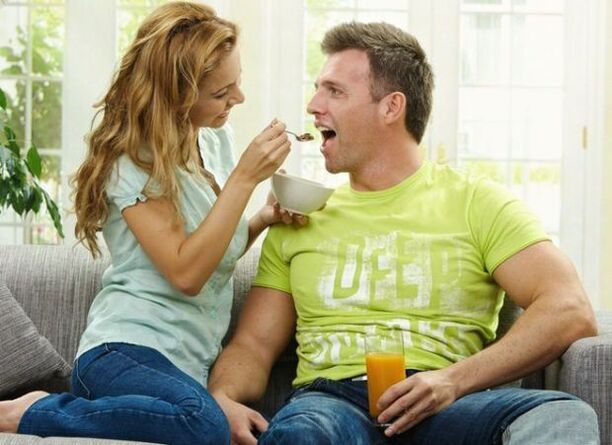 a woman feeds a man with potency-boosting products